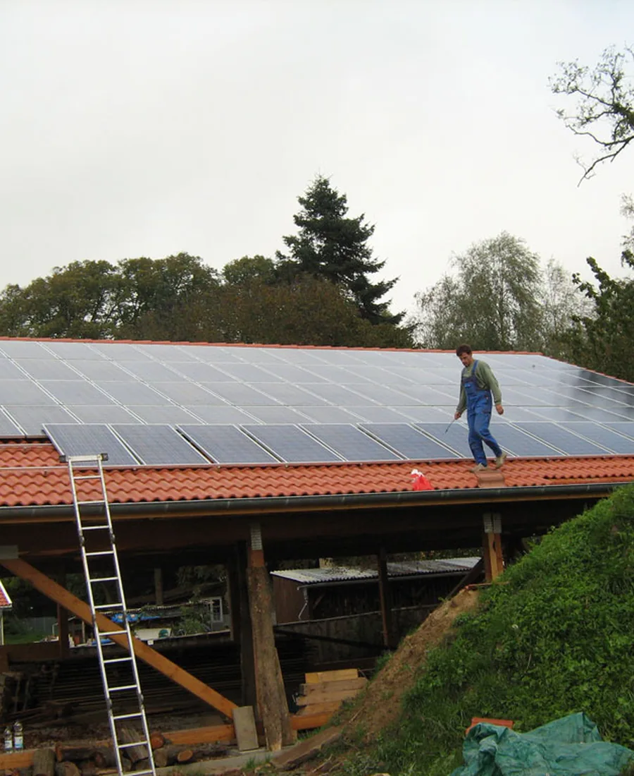 Dach eines Einfamilienhauses mit Photovoltaikmodulen, von der Straße aus gesehen