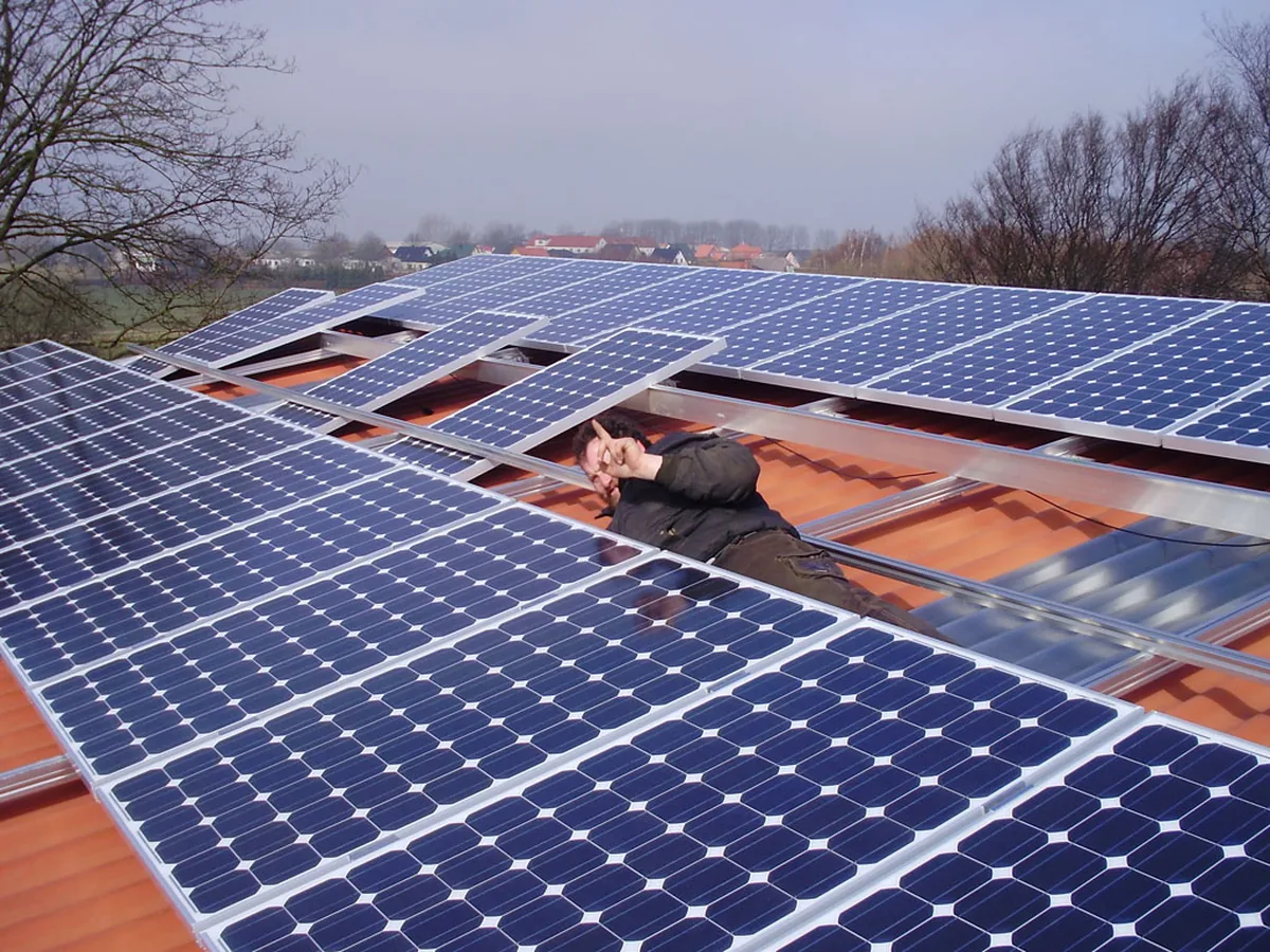 Monteur bei der Installation von Photovoltaikmodulen auf einem Dach